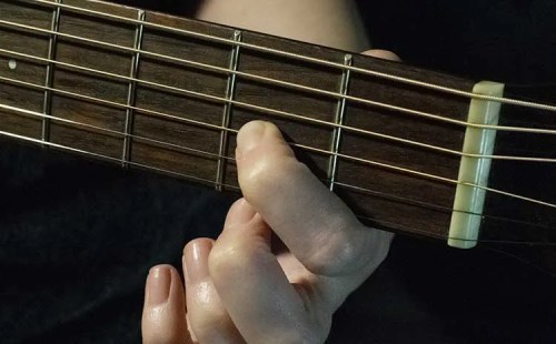 fingers on guitar fretboard alternate tunings