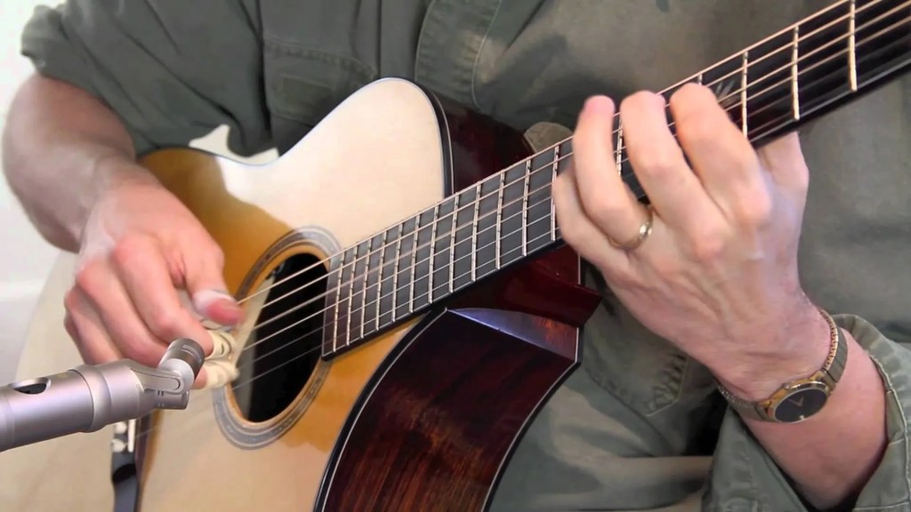 someone strumming acoustic guitar