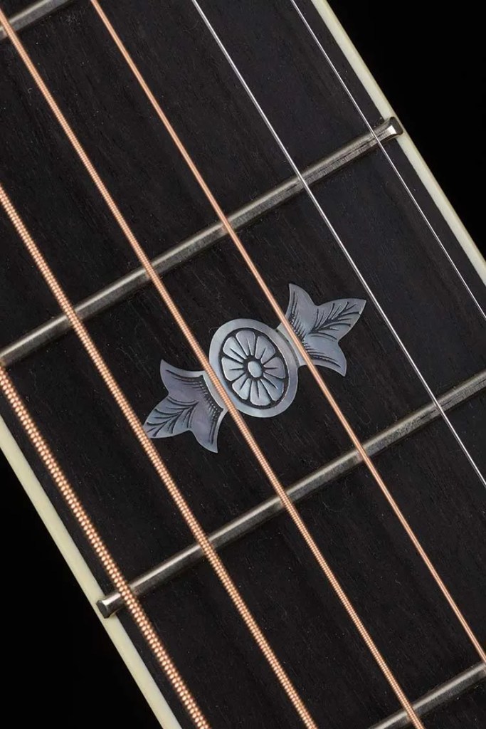 Closeup of a Collings OM3 custom acoustic guitar fretboard markers