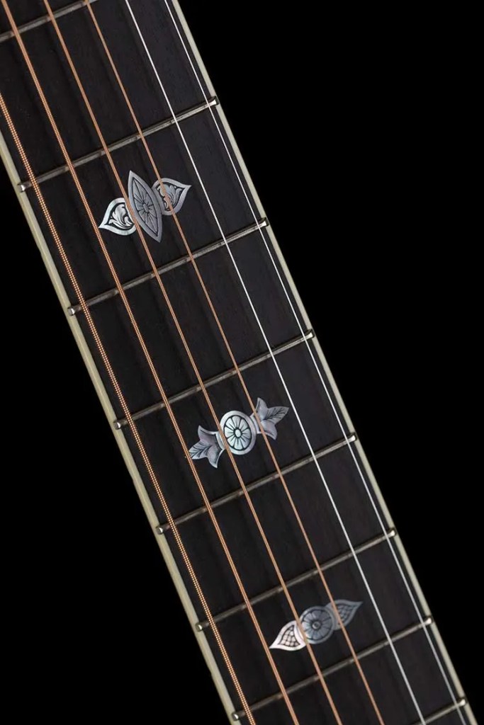 Closeup of a Collings OM3 custom acoustic guitar fretboard markers