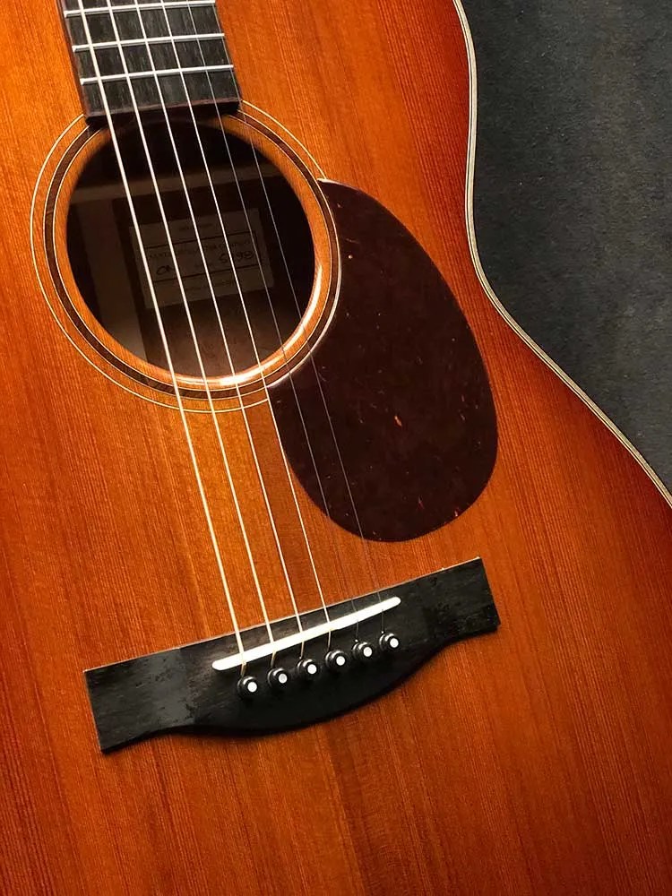Closeup of pickguard, soundhole, and bridge of a 2021 Santa Cruz OM Custom acoustic guitar made from Tunnel 13 Redwood