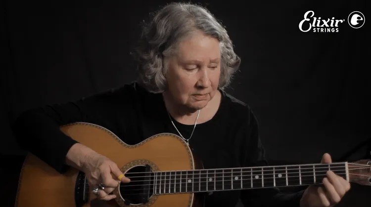 mary flower playing her guitar