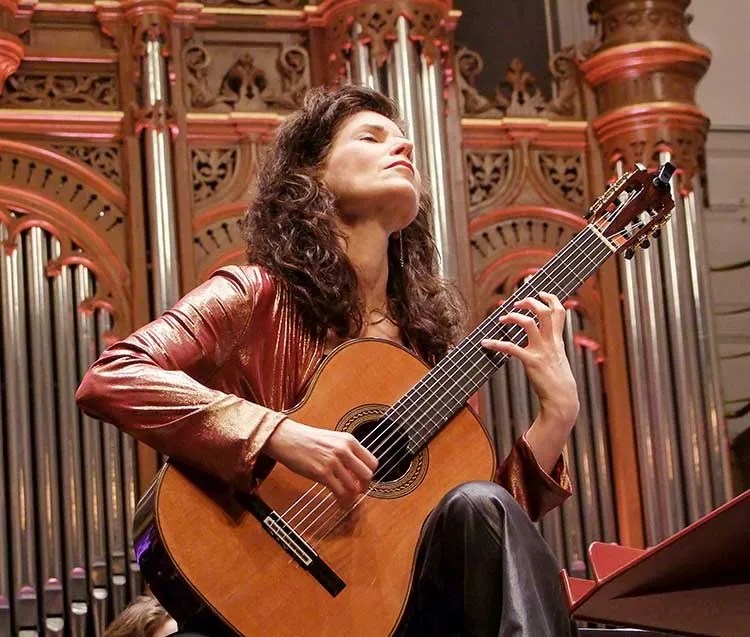 Sharon Isbin playing guitar in front of a pipe organ